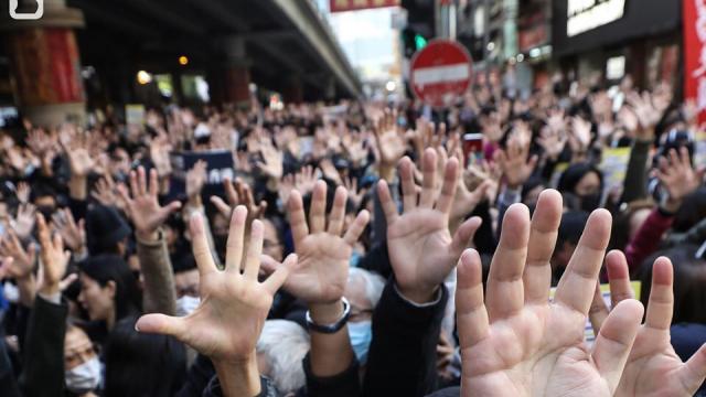 Protestors with their hands up and wearing masks in Hong Kong