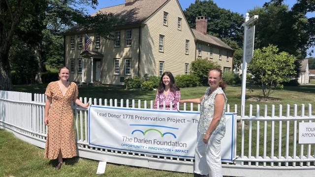 Sophye Davey (on the far left) hanging up a poster with her co-workers, Emma Grayeb (middle) and Crisiti Mohr (right).
