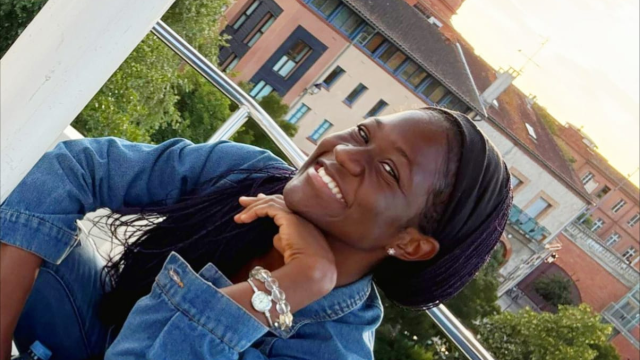 A smiling person poses on a ferris wheel with the Chapelle de La Grave in the background