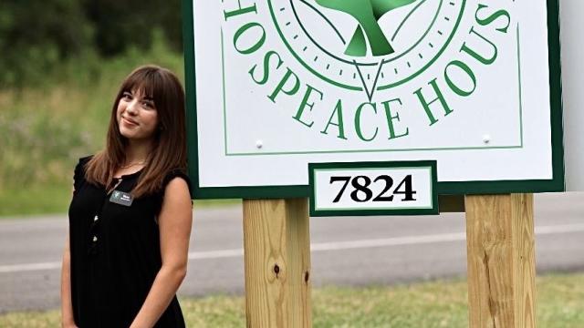 Student Intern, Elena Dickinson, shown in front of Hospeace House sign in Naples, NY. 