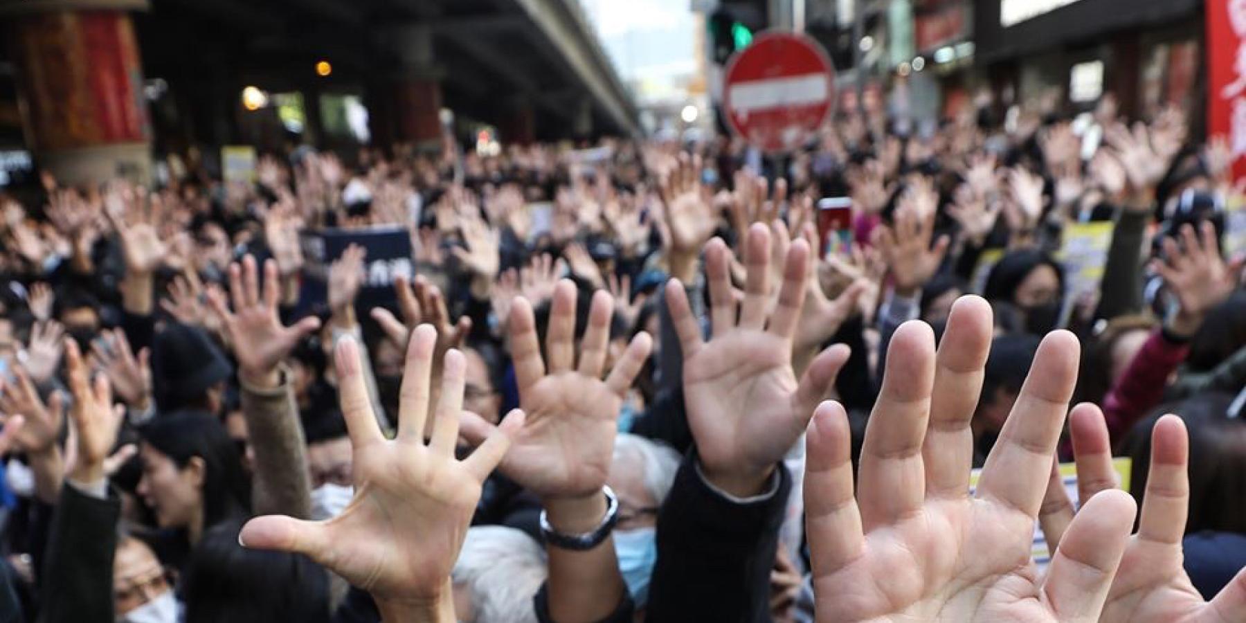 Protestors with their hands up and wearing masks in Hong Kong