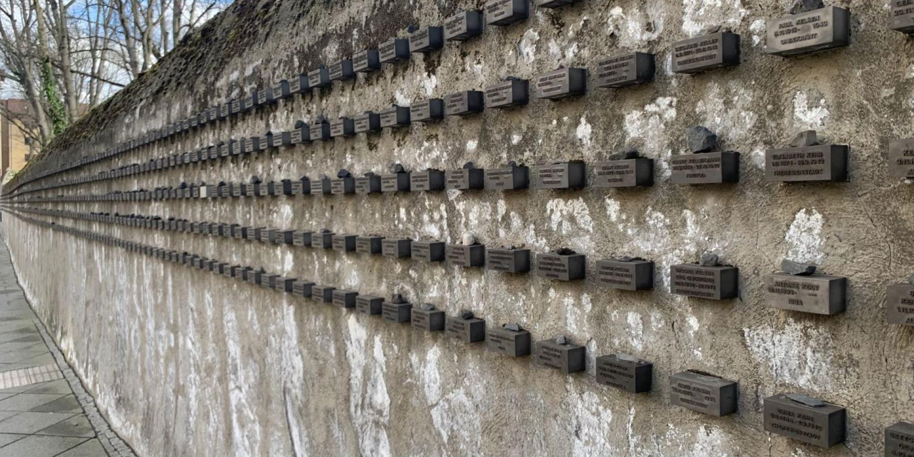 A stone wall with small placards.