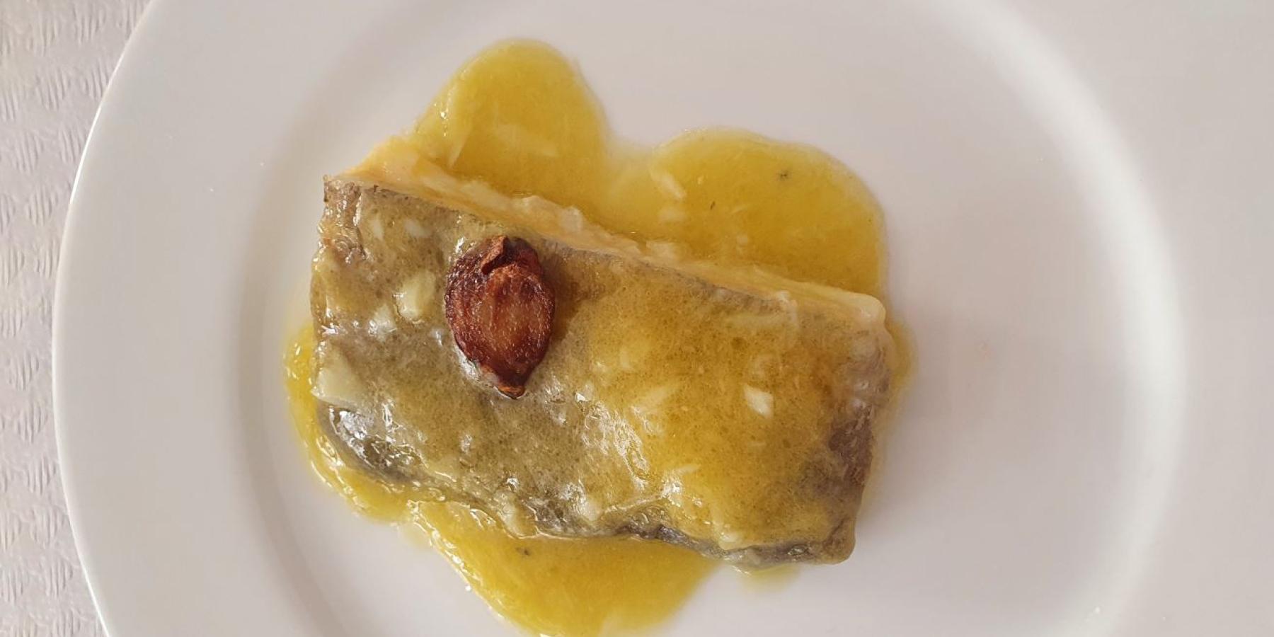 A white plate with food and sauce on it.