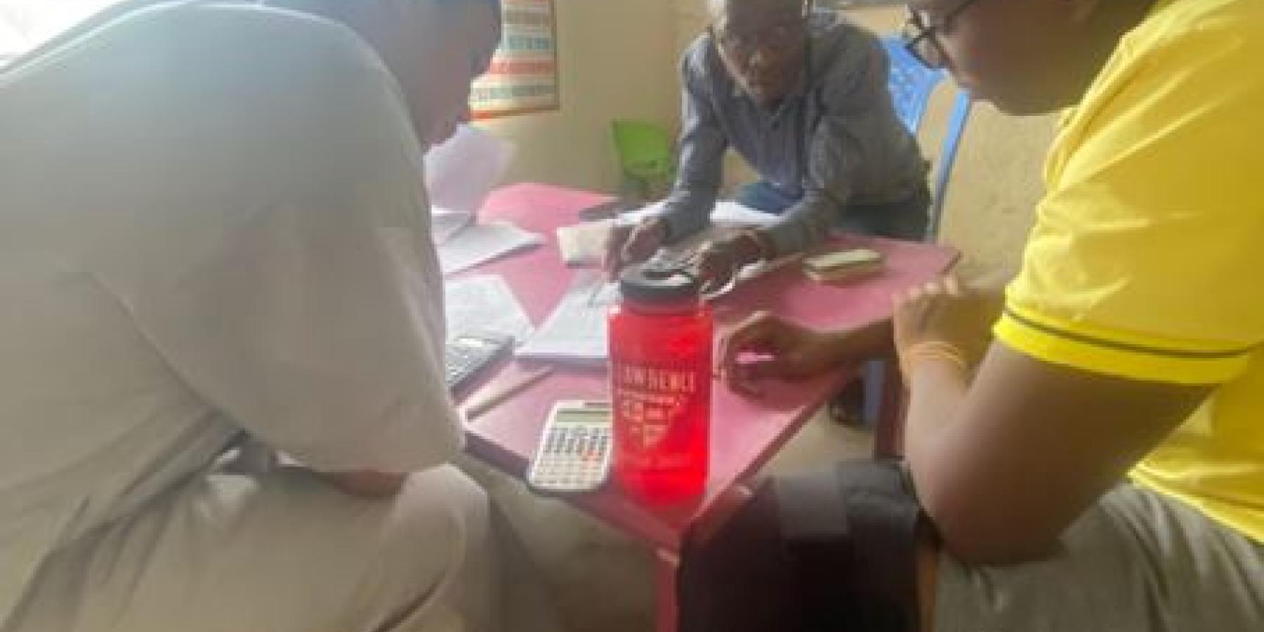 Three men sit around a table.