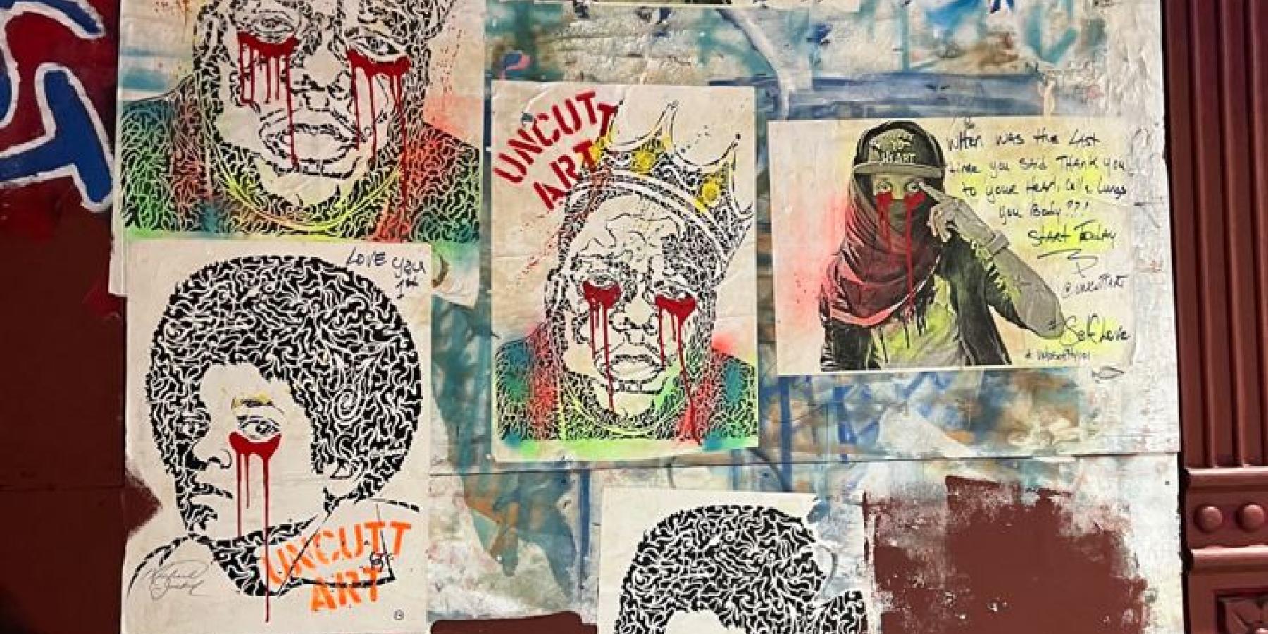 A collage of portraits glued to a wall, splattered with paint that resembles red teardrops from coming from the portraits&#039;  eyes.