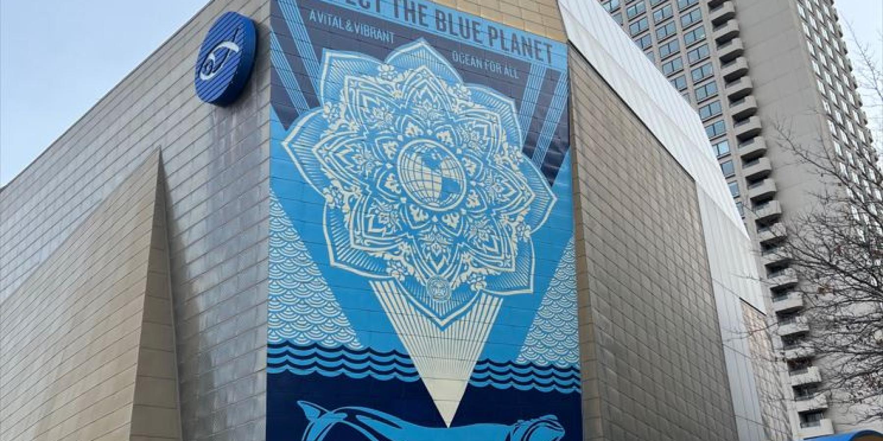 A large blue geometric mural on the wall of a modern building.