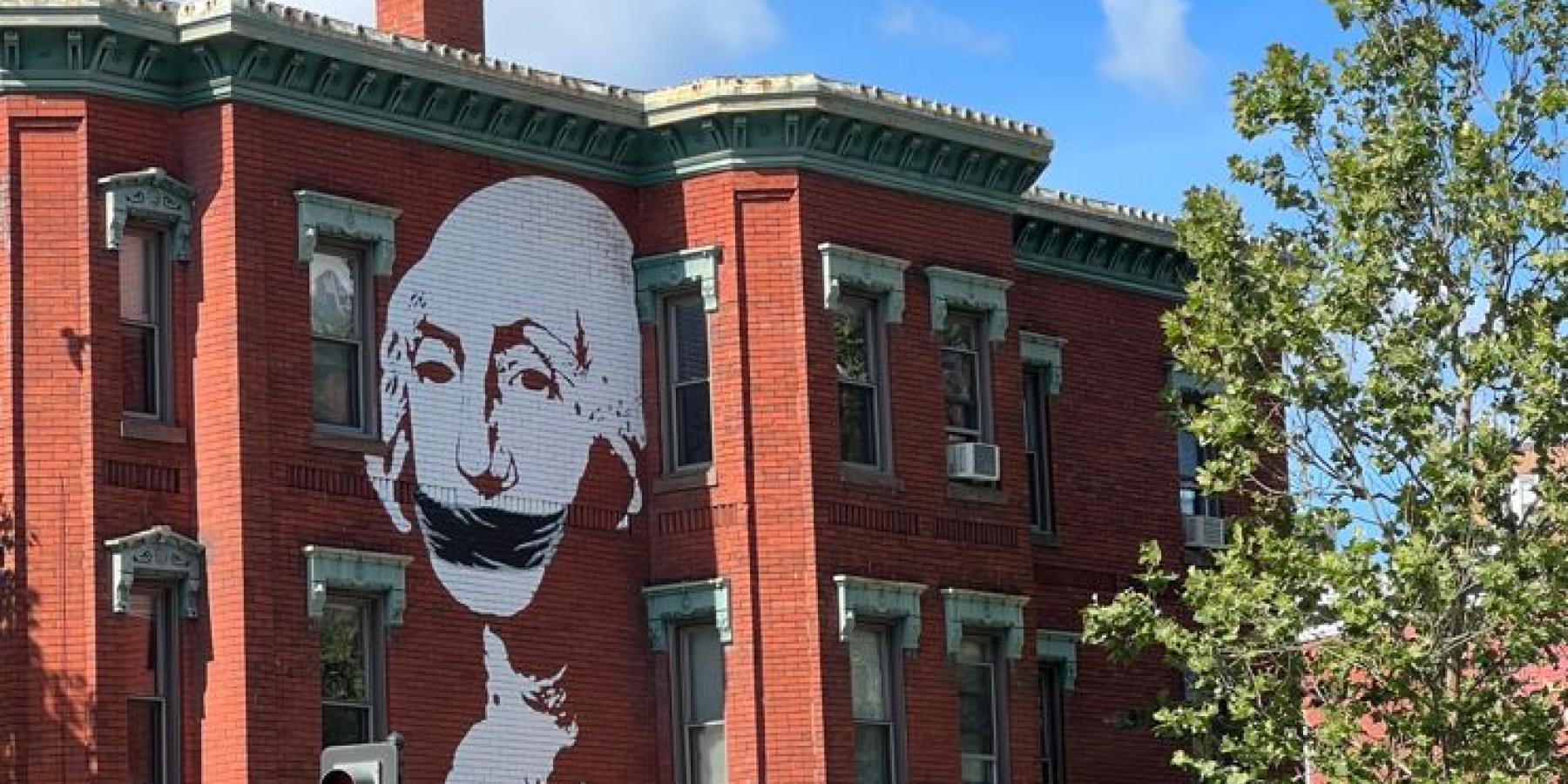 A large, high-contrast mural showing George Washington, but gagged.