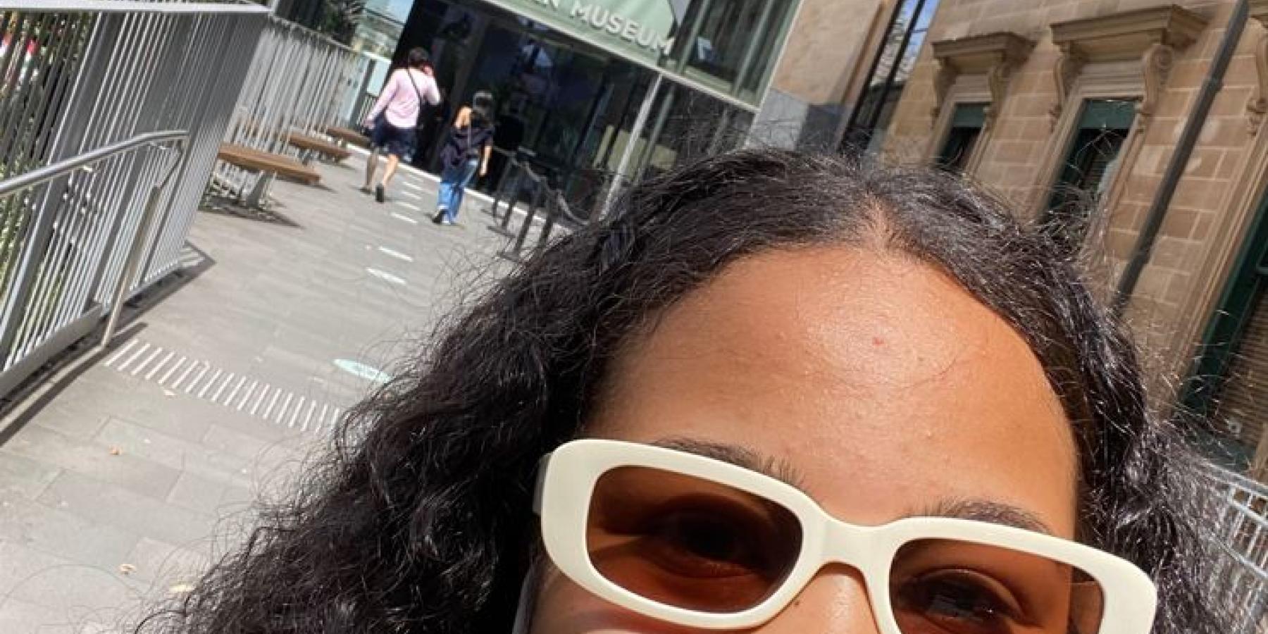 Luisa takes a selfie while walking out of a museum.