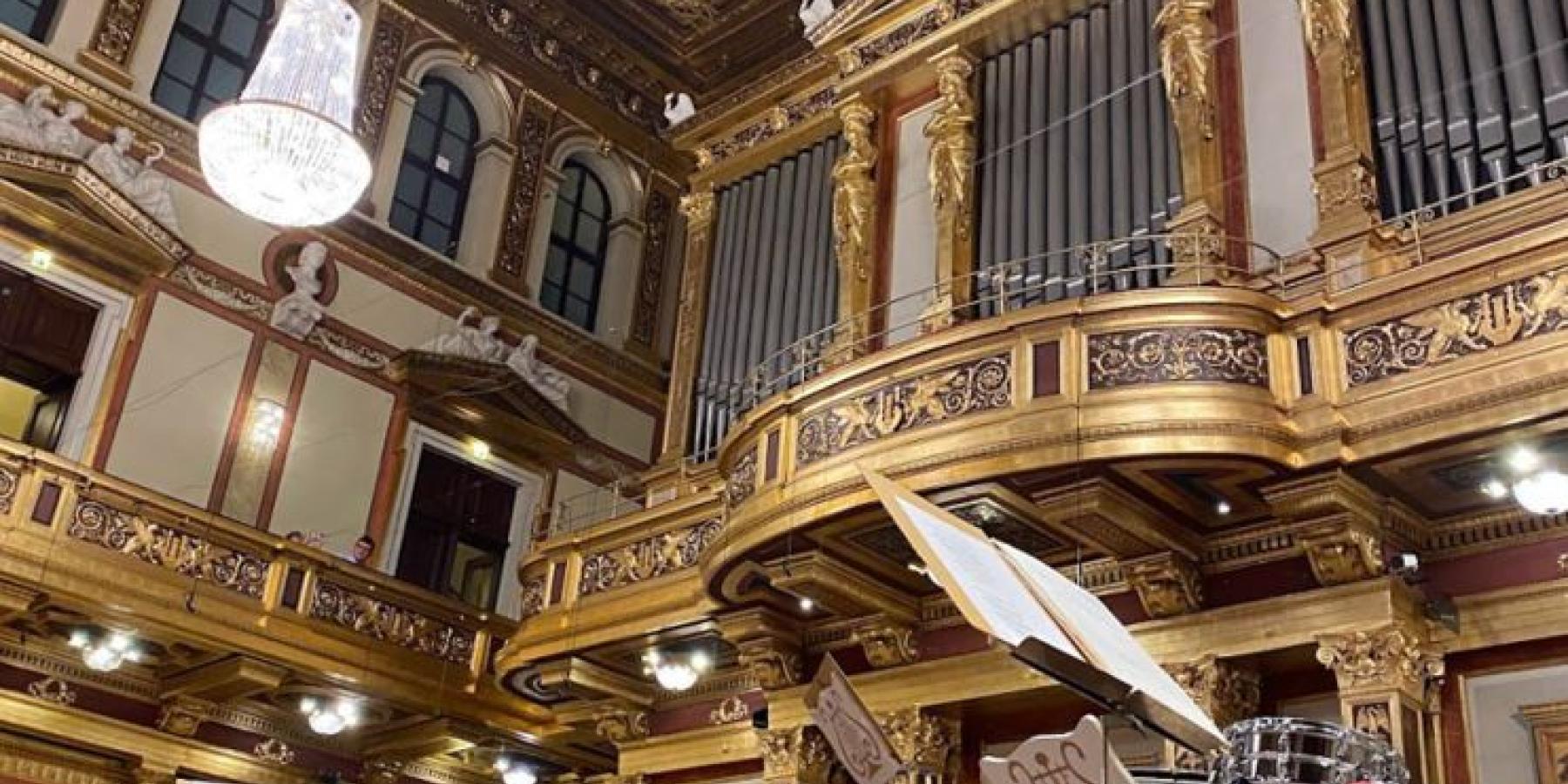 A photograph depicting an ornate organ and drumsets.
