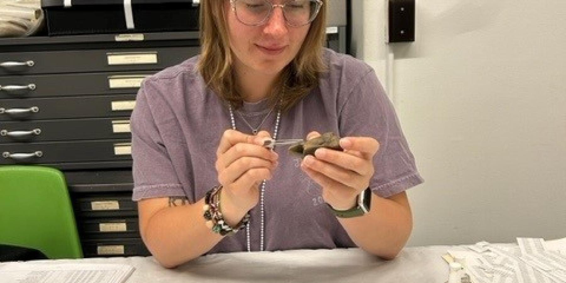This image is of Caitlin Erb labeling artifacts for her Internship.