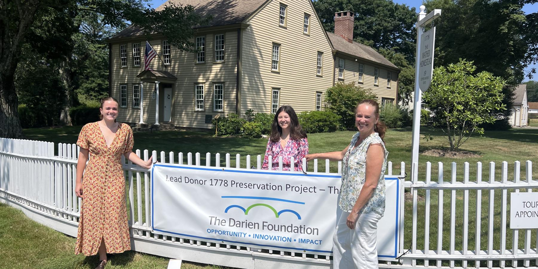 Sophye Davey (on the far left) hanging up a poster with her co-workers, Emma Grayeb (middle) and Crisiti Mohr (right).