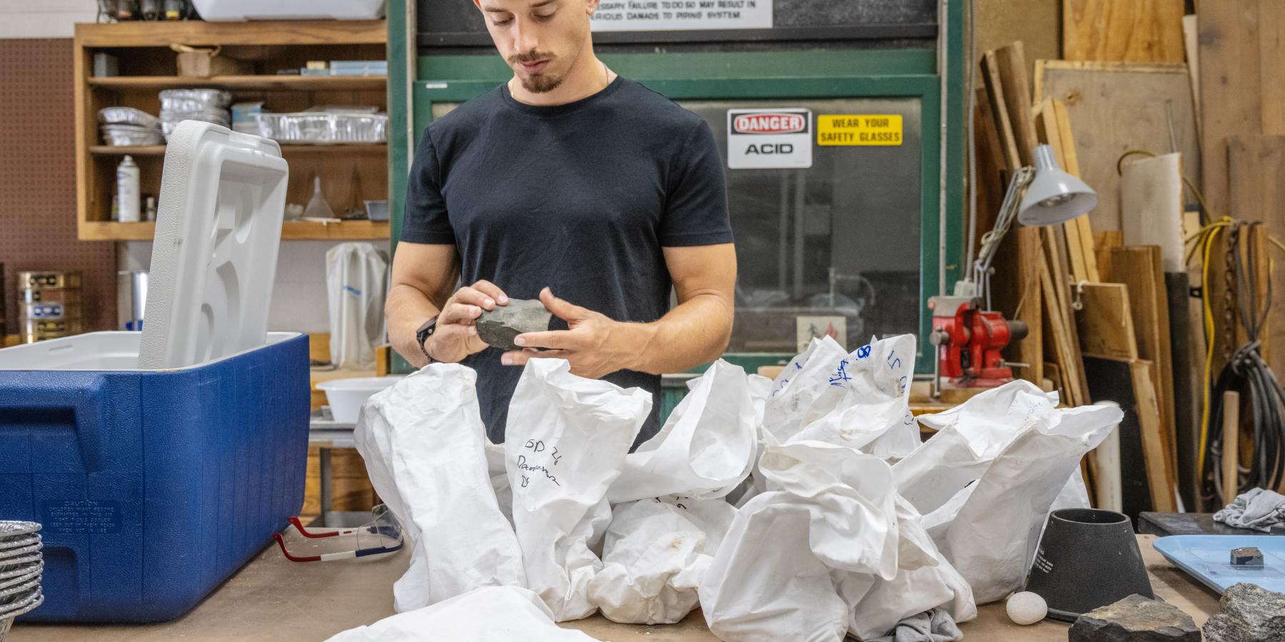 Image of Geo with geologic sampling bags.