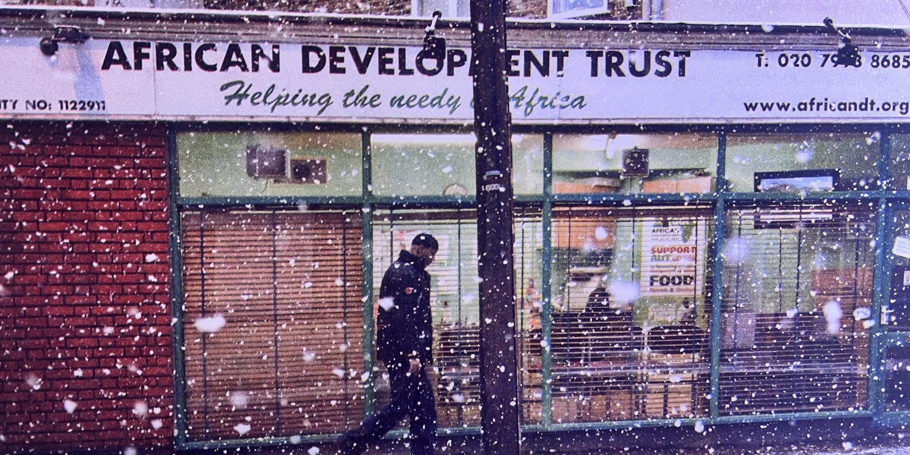 Johny Pitts’s black-and-white photograph African Development, Finsbury Park (2010), showing a person standing outside the African Development Trust storefront in London, displayed as part of the artist’s Black Bricolage exhibition at the Maison Européenne de la Photographie in Paris.