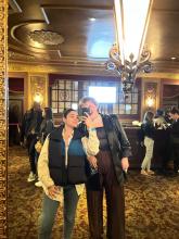 Sara and a friend take a selfie in front of a mirror.