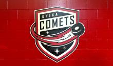 Utica Comets Shield Logo on a Red wall