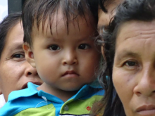 Mother In the background being partially blocked off halfway by her child and a grandma in the front of the image to the right 