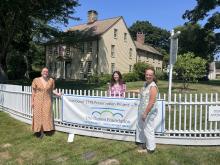 Sophye Davey (on the far left) hanging up a poster with her co-workers, Emma Grayeb (middle) and Crisiti Mohr (right).