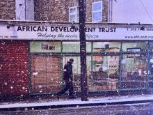  Johny Pitts’s black-and-white photograph African Development, Finsbury Park (2010), showing a person standing outside the African Development Trust storefront in London, displayed as part of the artist’s Black Bricolage exhibition at the Maison Européenne de la Photographie in Paris.