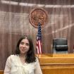 The picture is taken at the Superior Court of Los Angeles county and displays the judges seat with a flag of United States of America.