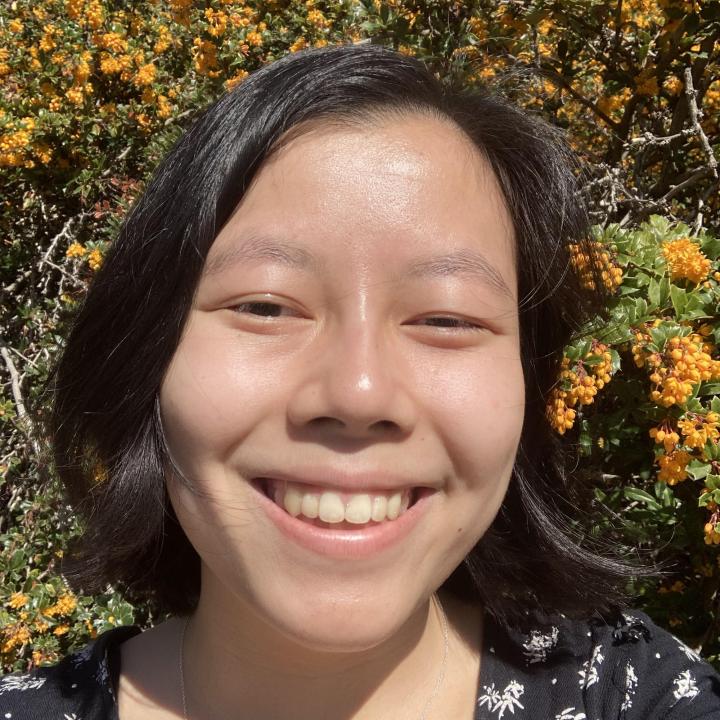 Photo of Grace Brouillette in front of a flower bush