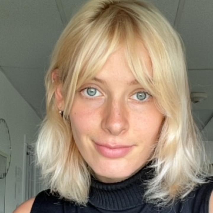 Headshot in a black turtleneck, smiling into the camera.