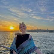 Photo of Emma Caffrey at sunset on the water.