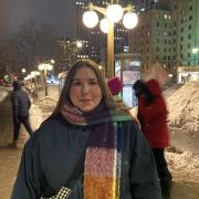A woman standing in a winter setting with a colorful scarf.