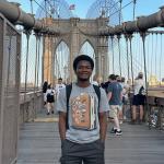 A photo of me standing on the Brooklyn bridge.