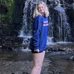 A photo of Keely Snode, in front of a waterfall in New Zealand