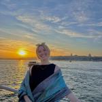 Photo of Emma Caffrey at sunset on the water.