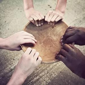 Hands holding a wooden plate.