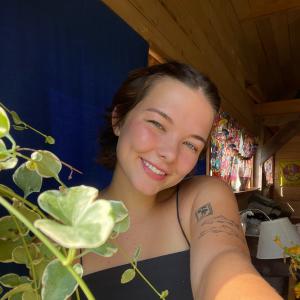 A short-haired girl (Madeline) in a tank top smiling at the camera. 