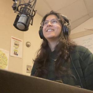 Smiling woman sitting at radio station desk