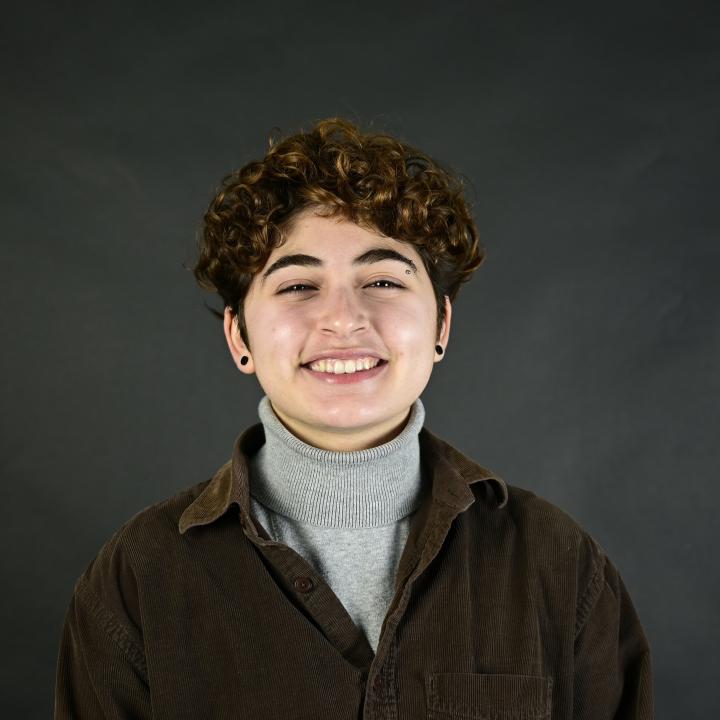 A photo of Kam, centered and smiling.